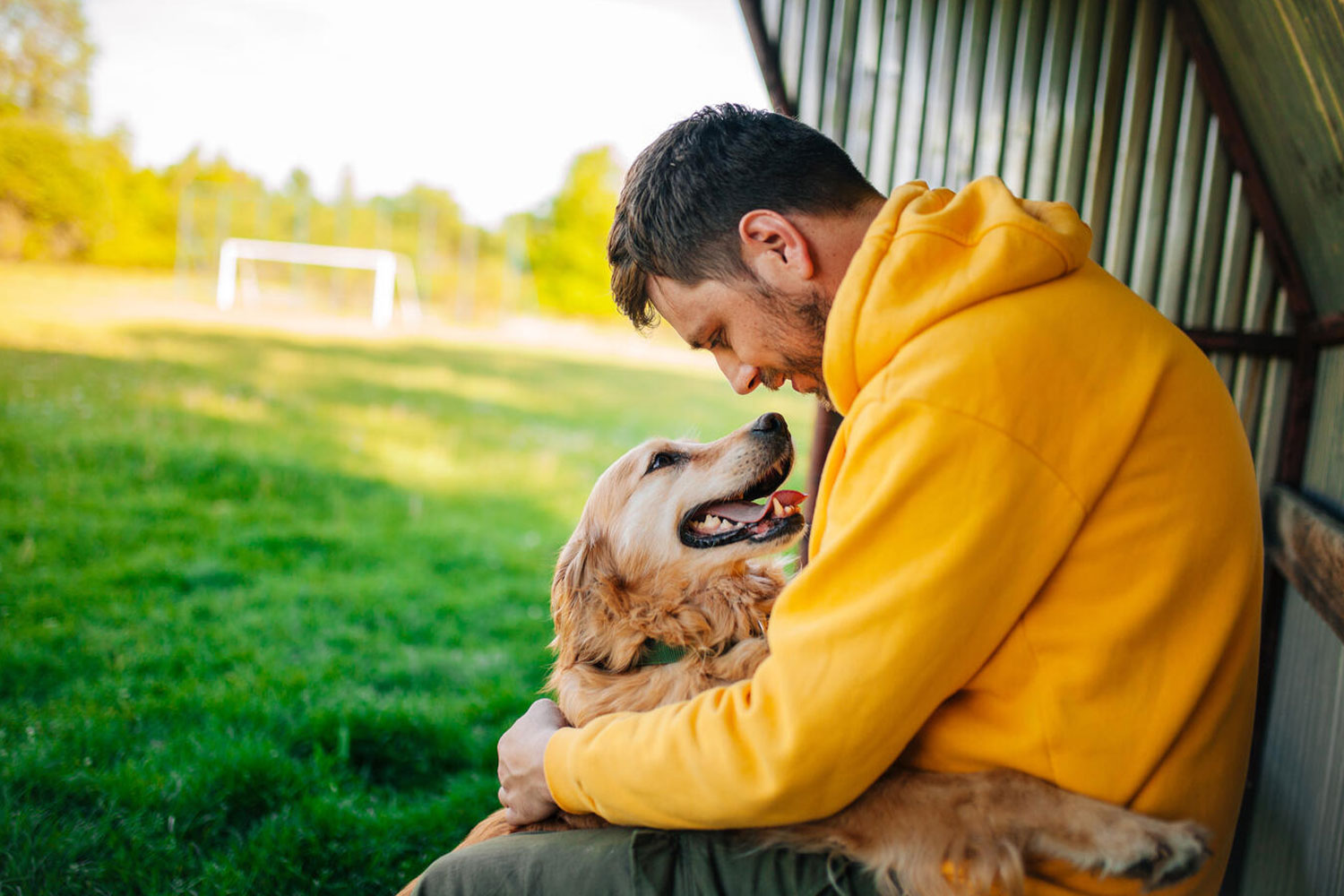 a man leaning over and hugging his dog