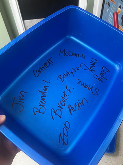 Photo showing a litter box with names written on the bottom.