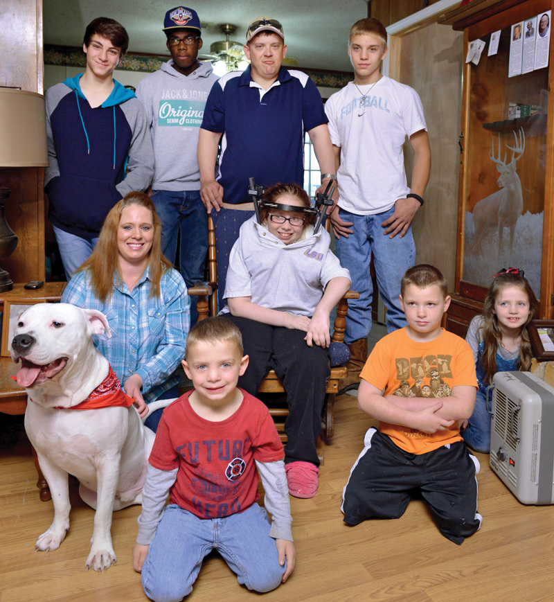 a group of adults and children with a white dog