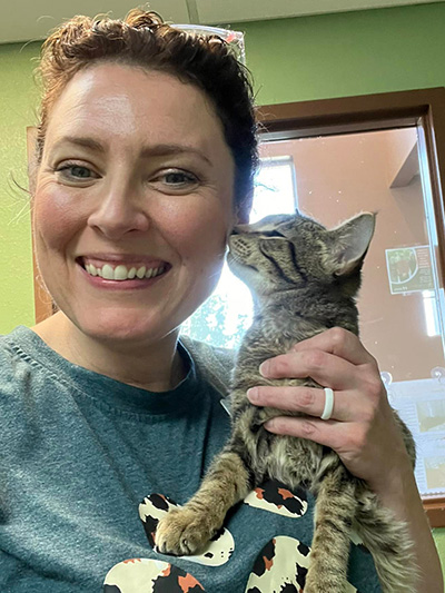 a woman holds up a kitten