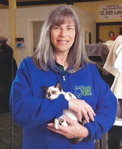 a woman cradling a kitten