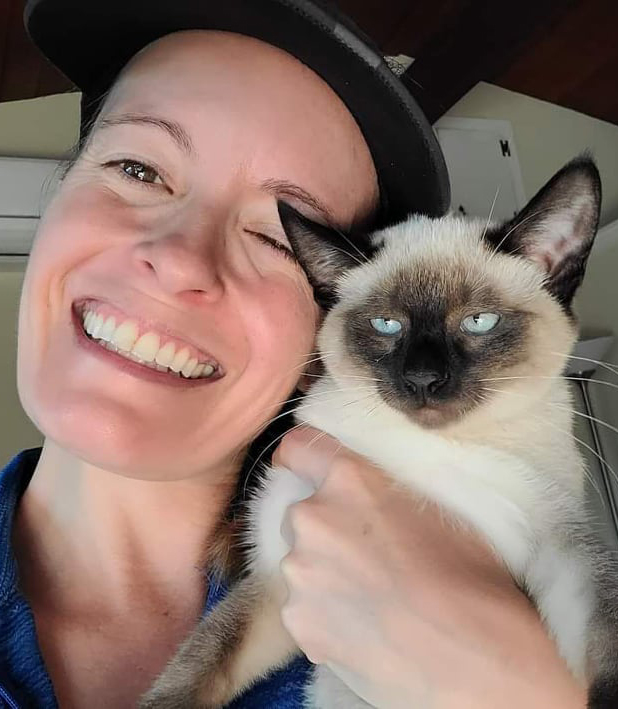 a woman holds up her foster cat