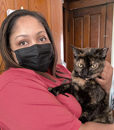 A woman in a mask holding a cat.