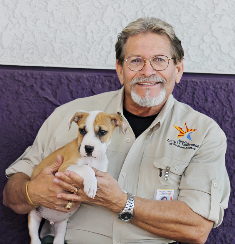 a man holding up a puppy