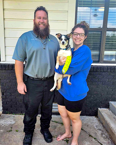 An animal control officer with a found dog and its owner.