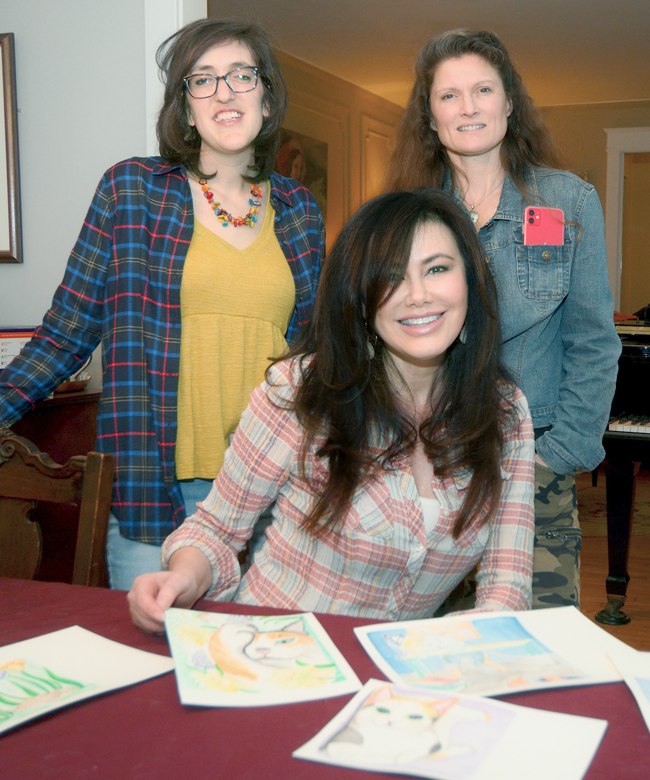 three women posing in front of book pages