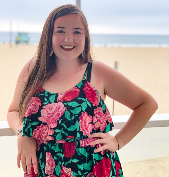 a woman leaning on a railing near a beach