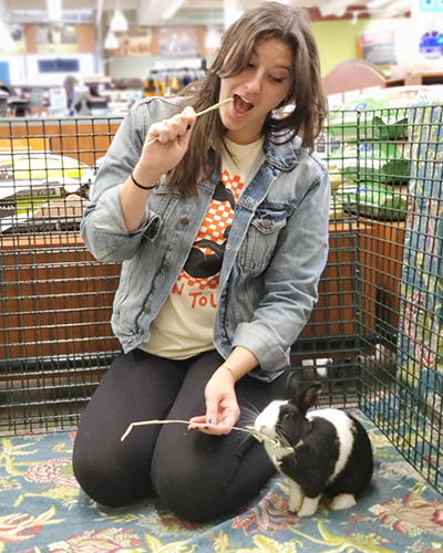 A volunteer plays with a bunny.