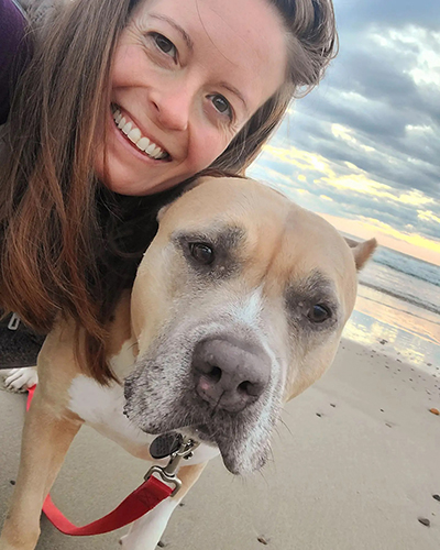 Lindsay Hamrick on the beach with Nova the dog.