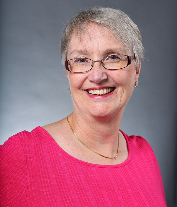 headshot of a woman in a pink sweater