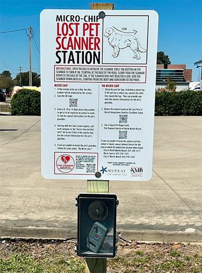 instructional sign above a microchip scanner station