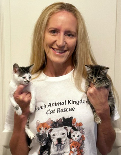 Laura Zurawski holding two kittens, wearing a t-shirt that says Hope's Animal Kingdom Cat Rescue.