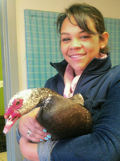 a smiling woman holding a duck