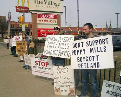 a group of people holding signs protesting puppy mills