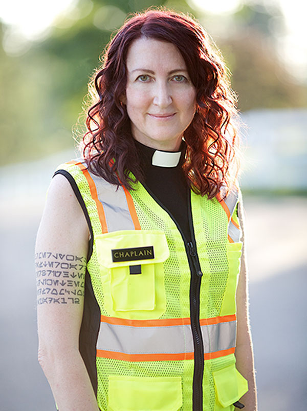 a woman wearing a yellow vest that says chaplain