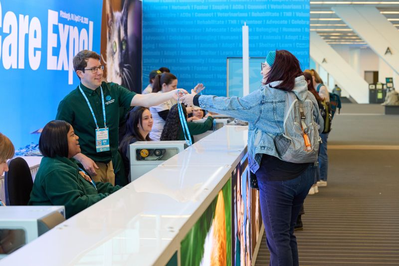 Staff handing badge to an attendee at registration desk