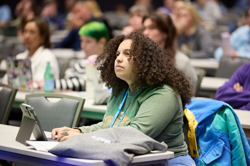 Attendee in workshop typing on laptop