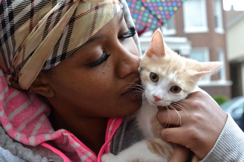 a woman kissing a kitten