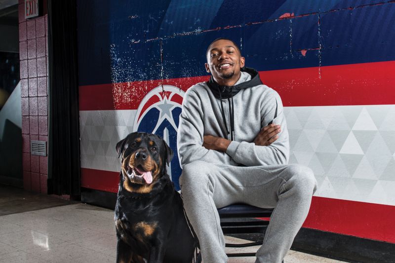 a man sitting on a chair next to a dog