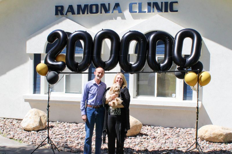 Photo of Dr. Popa with a client and their dog in front of the Romana Clinic.