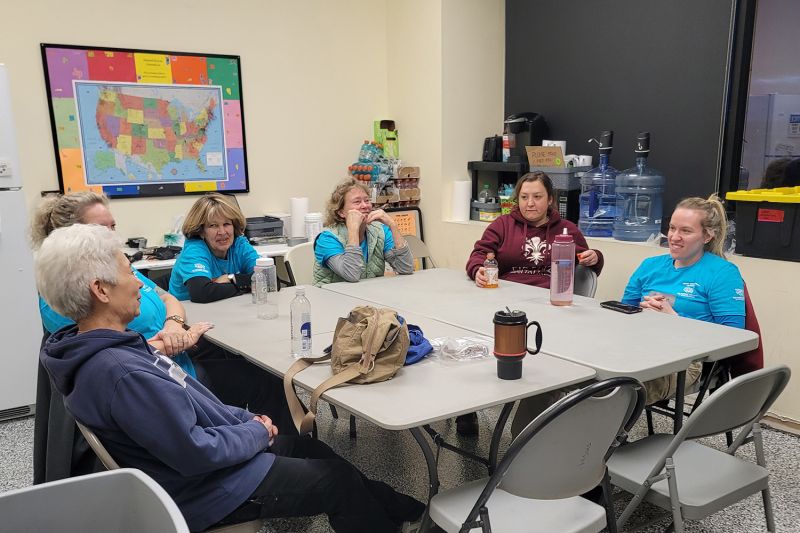 A group of volunteers sitting at a table in the care and rehab center.