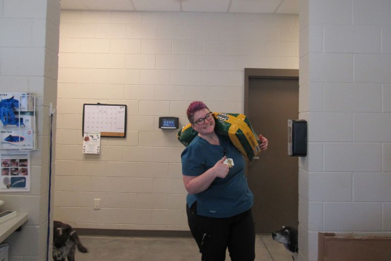 a woman carrying a large bag of food and giving a thumbs up