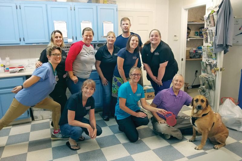 a group of smiling people with a dog