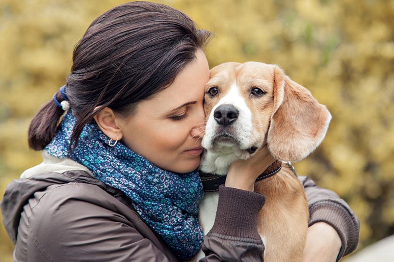 a woman snuggling a dog