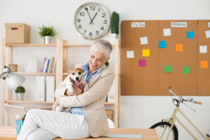 a woman holding a dog in an office setting