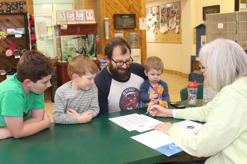 a woman meeting with a man and his three sons