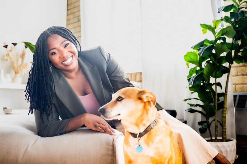 a woman leaning on a couch with a dog