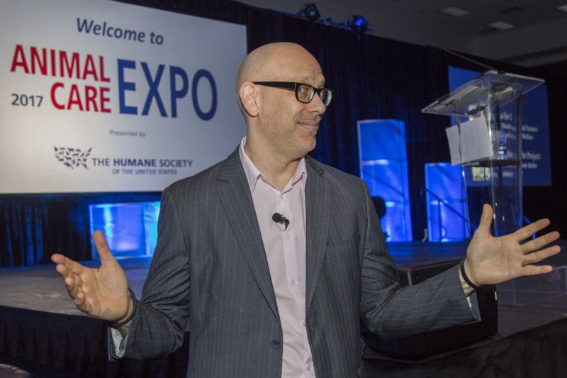 a man standing in front of an Animal Care Expo sign