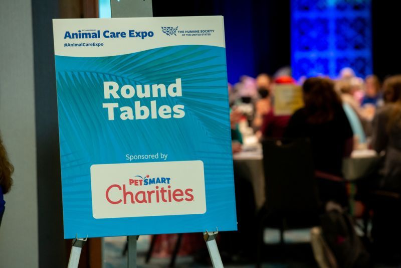 a sign for the round tables event displaying a sponsor logo