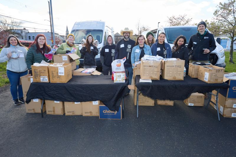 Volunteers standing behind a food distribution table