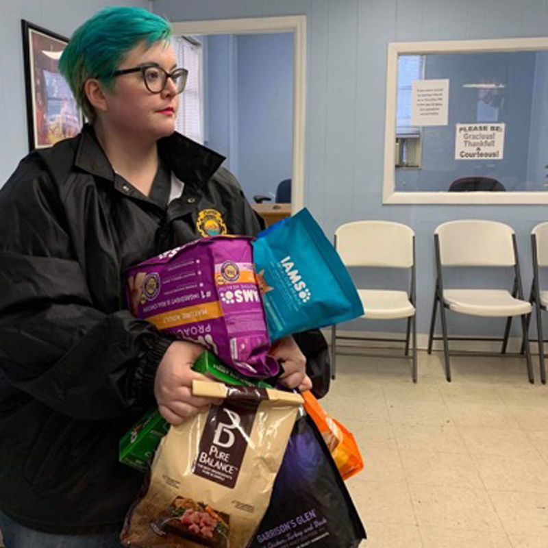 a woman carrying many bags of pet food
