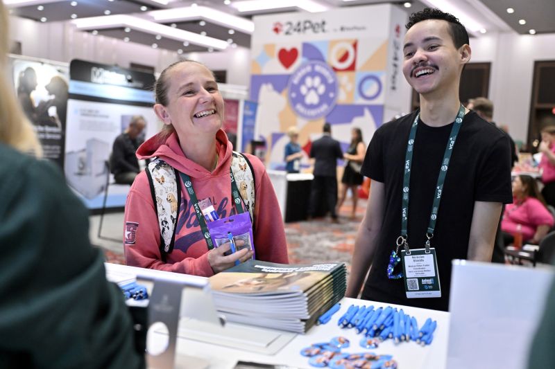 Two people laughing at a booth