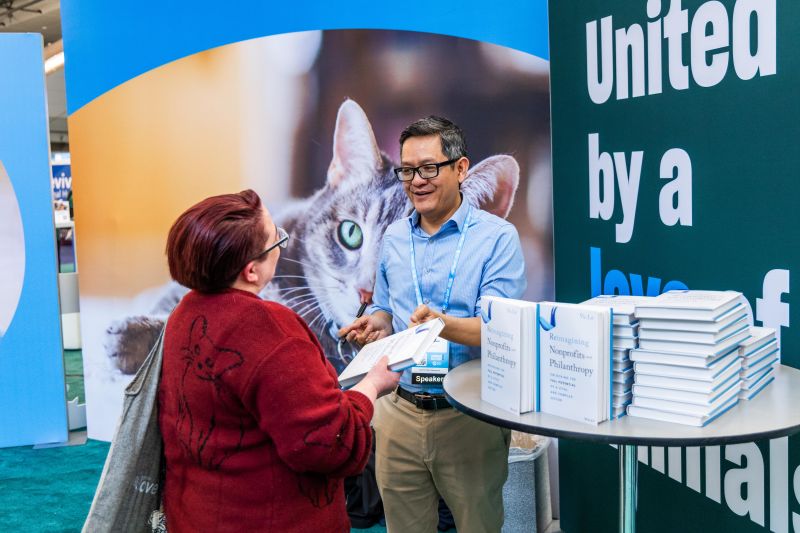 Vu Le signing a book for an attendee