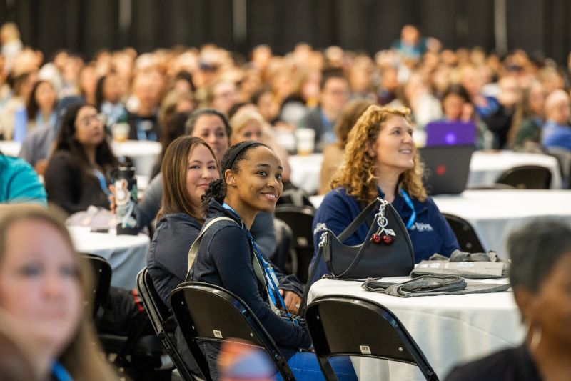 Attendees smiling watching the main stage