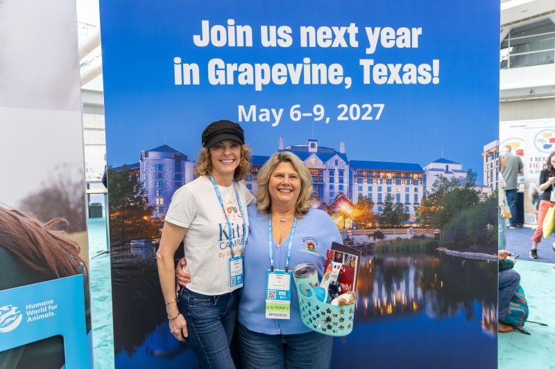 Two women in front of an Expo 2027 sign