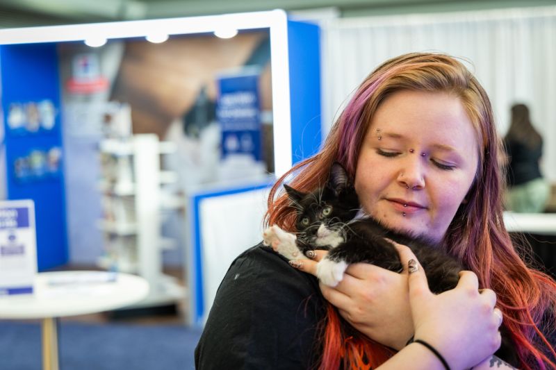 Attendee holding a black and white kitten