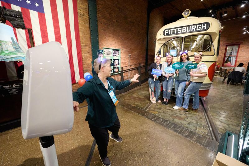 Attendees using photobooth in front of Pittsburgh train car