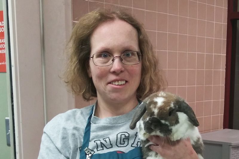 a woman holds up a rabbit