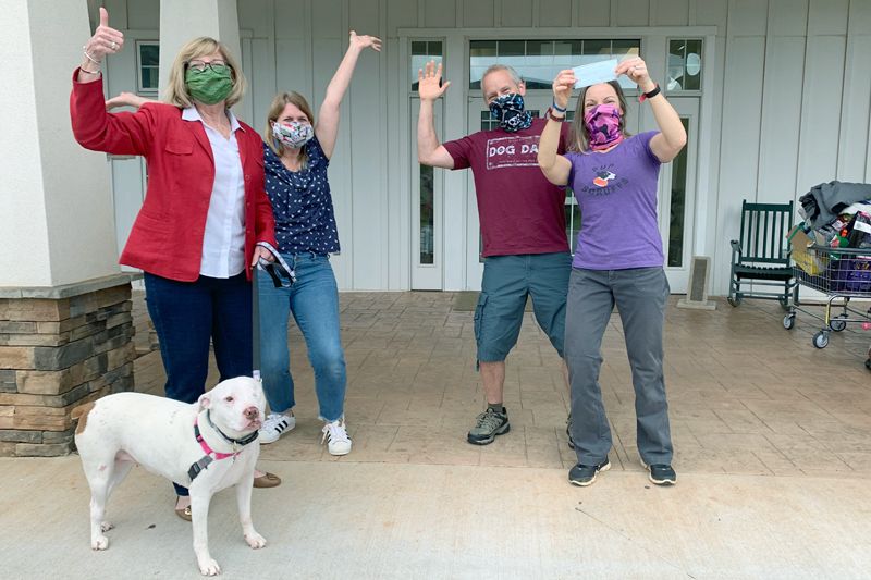 a group of masked people holding up a check