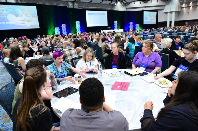 a group of people gathered around a table in discussion