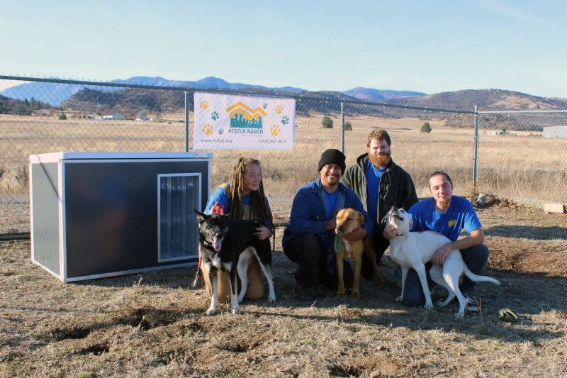 HSUS Pets for Life team kneel next to an outdoor dog kennel