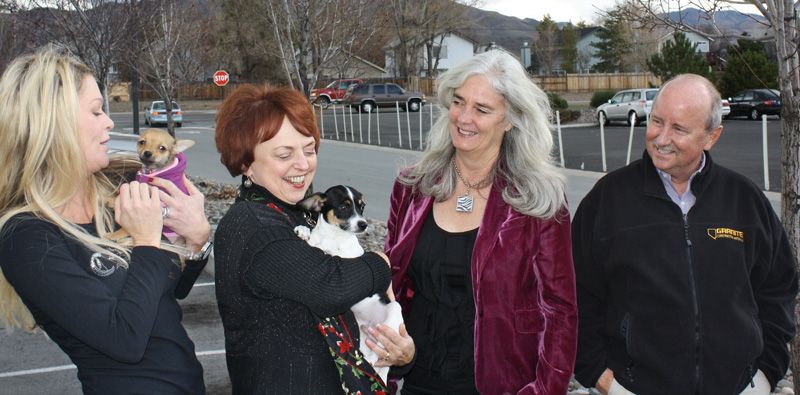 a group of people holding small dogs