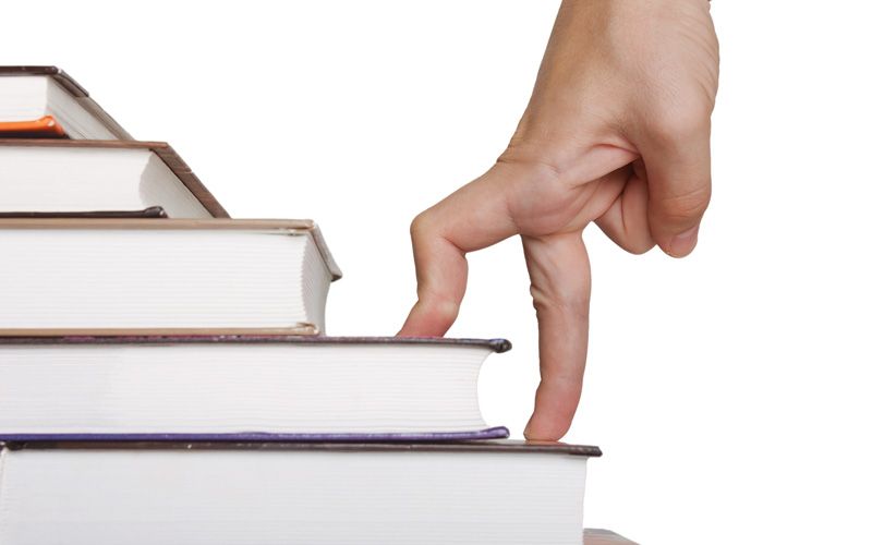 fingers walking up a stack of books