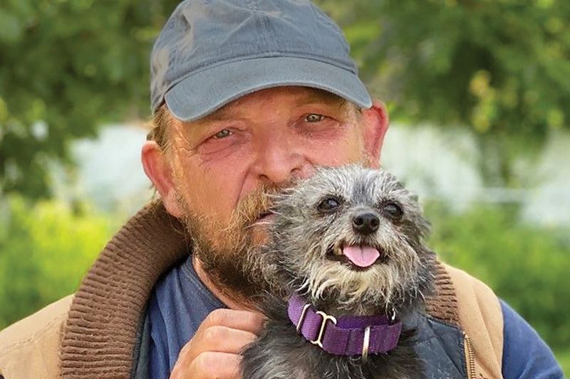 a man holding up his small dog
