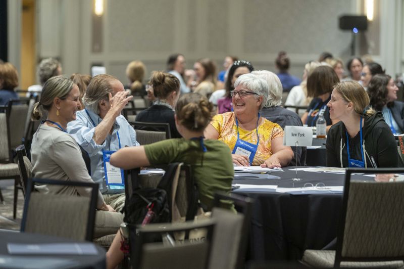 Attendees seated at a round table laughing