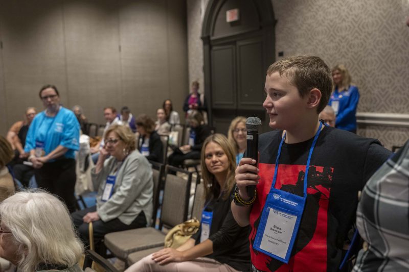 Young attendee speaking into a microphone